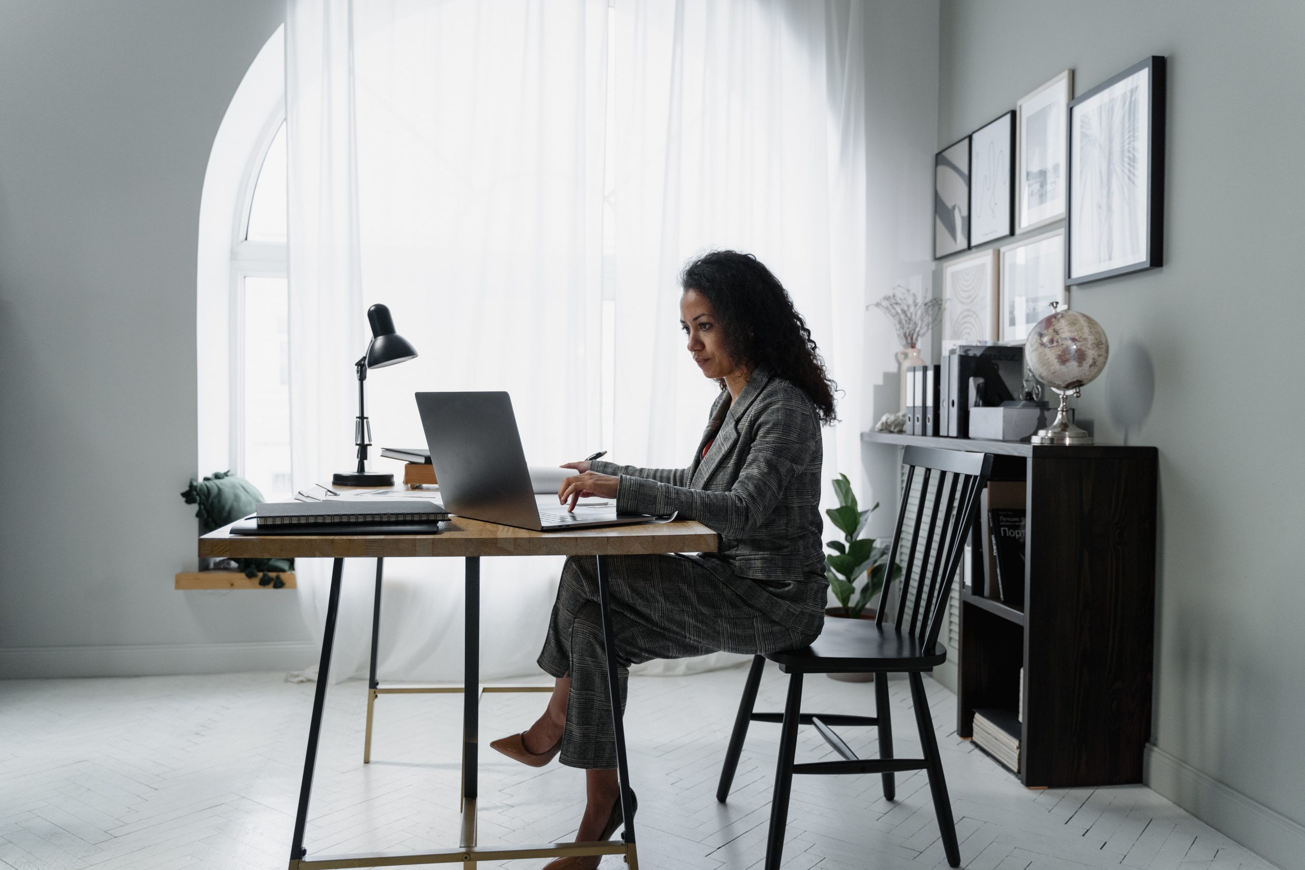 An entrepreneur focused on business growth while working on a laptop at a modern home office setup, embodying the concept of 'Amplifying Your Brand's Growth'.