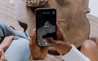 Person holding a smartphone with the TikTok app open, symbolizing the rise of video platforms in current social media trends