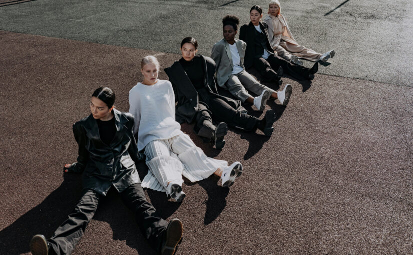 A diverse group of women sitting together on the ground in coordinated fashion, representing themes of Black feminism, activism, empowerment, and art.