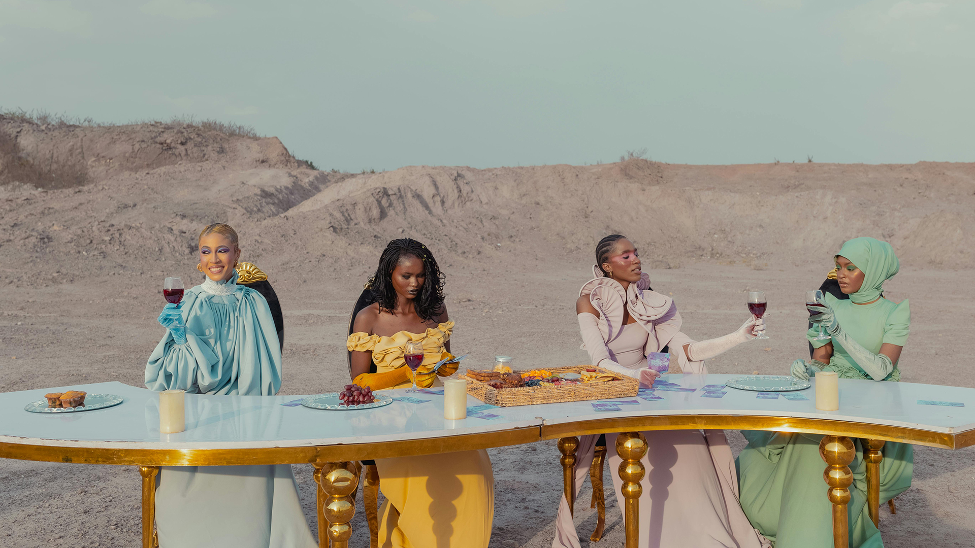 Women sharing drinks outdoors at a long table, dressed in elegant colours, symbolising making friends in your 40s and enjoying meaningful connection.